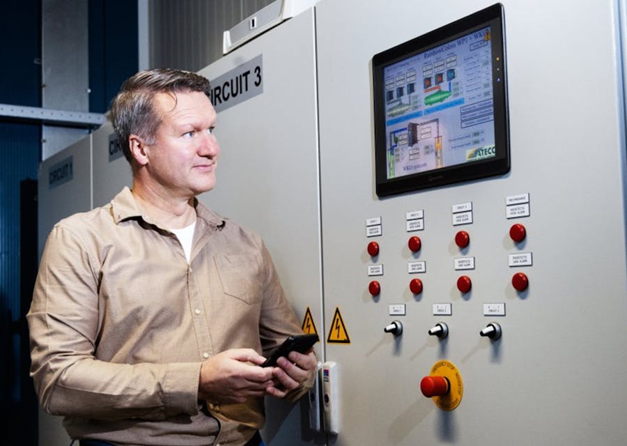 Tulpenbroeier Bas Karsten staat naast de regelkast van een elektrische installatie.