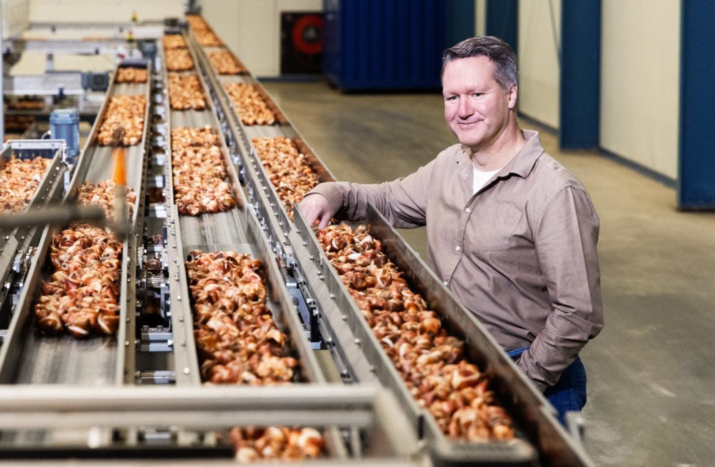 Tulpenbroeier Bas Karsten staat in zijn bedrijf, bij de producten waarmee hij werkt.