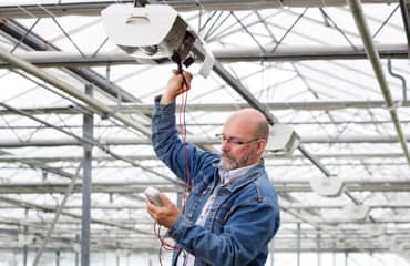 Een man doet een controlemeting in een kas