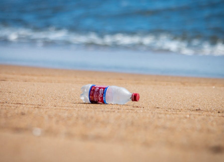 plastic flesje op  een strand