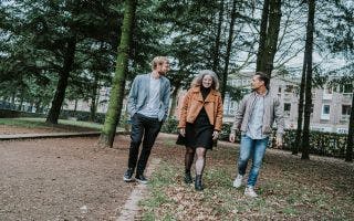 2 mannen en een vrouw lopen door een park