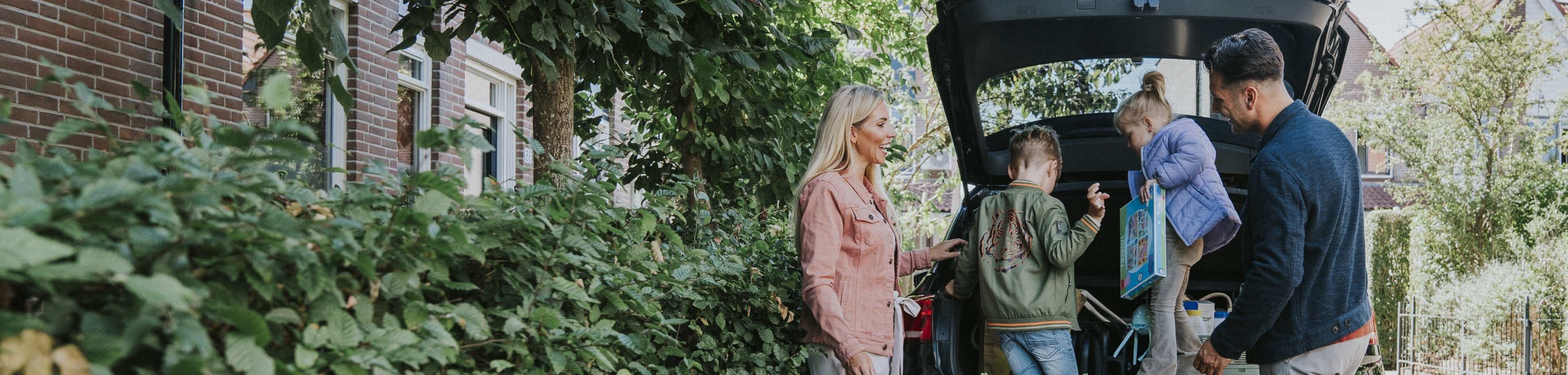 Gezin dat met kinderen in de auto op weg gaat. Ze hebben een autoverzekering van Interpolis.