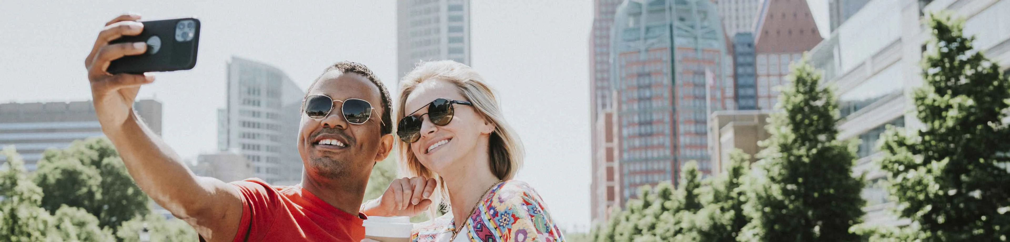 Man en vrouw die op vakantie zijn en een selfie maken. Ze sloten de doorlopende reisverzekering af met 15% korting op de premie.