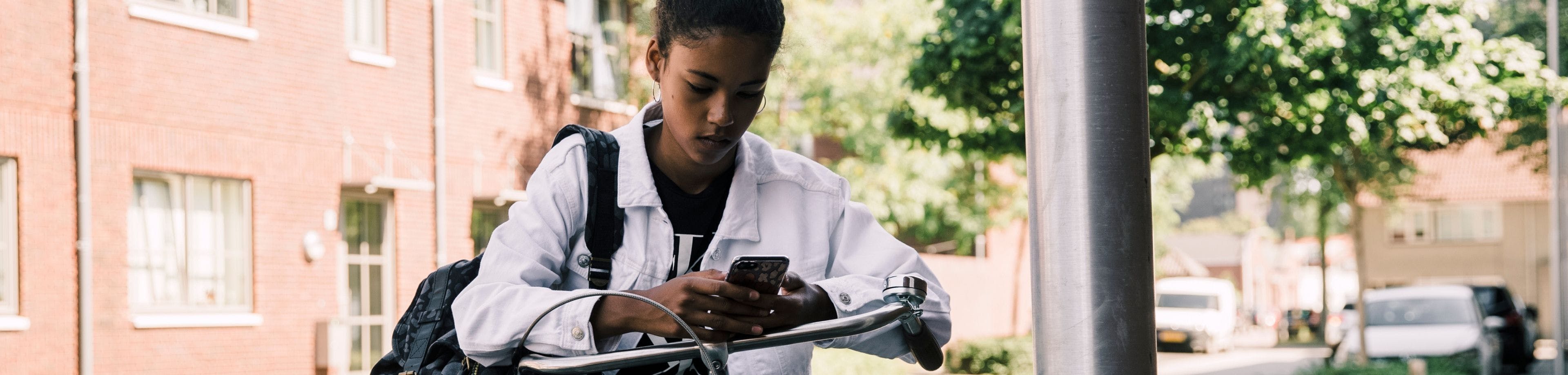 Jonge fietser kijkt op haar telefoon