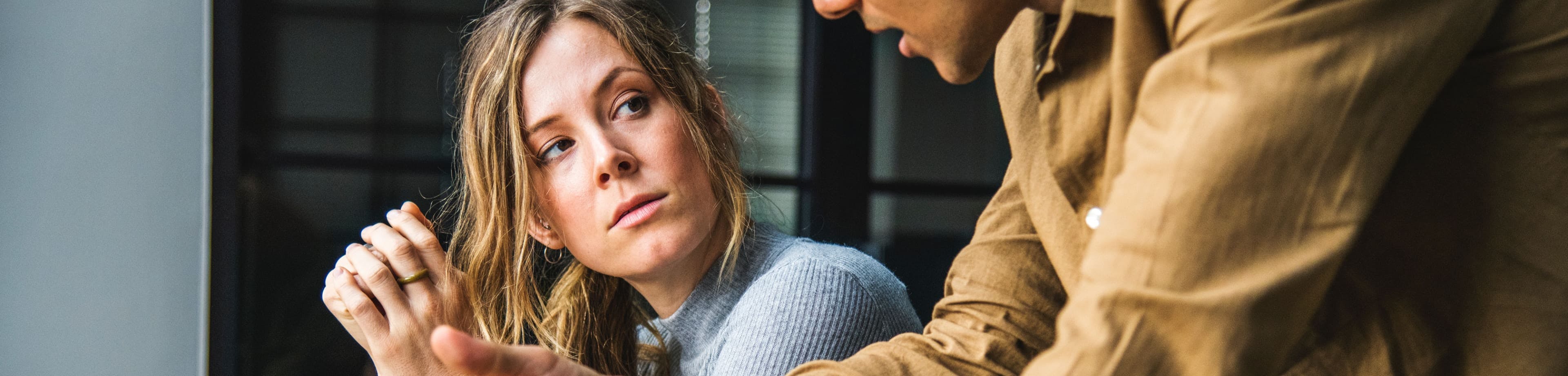 man en vrouw die op het werk met elkaar in gesprek zijn
