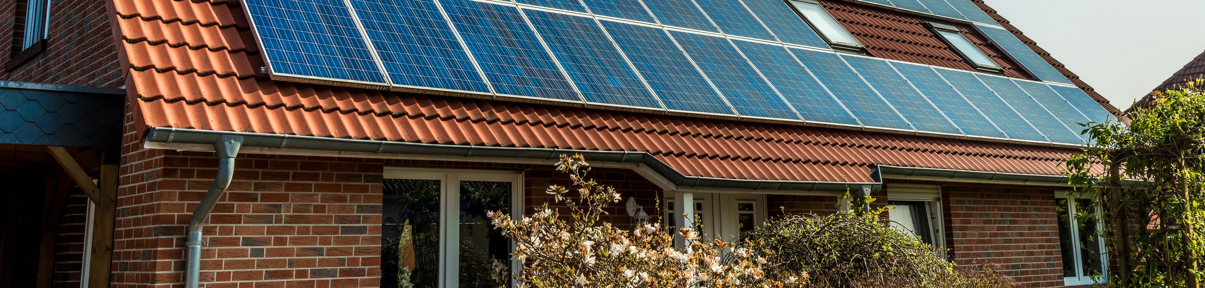 Dak van woonhuis met zonnepanelen. Zelf zonne-energie opwekken; de opties.