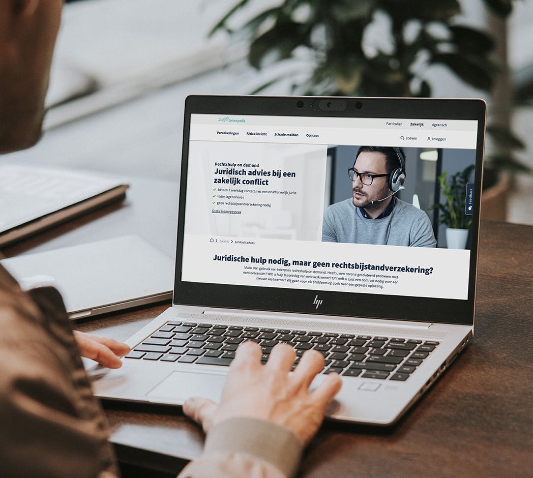 Iemand bekijkt op een laptop de webpagina van Interpolis over Rechtshulp on demand.