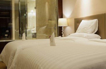 Opgemaakt bed in hotelkamer.