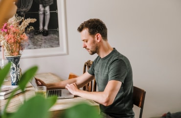 Een man zit achter zijn laptop