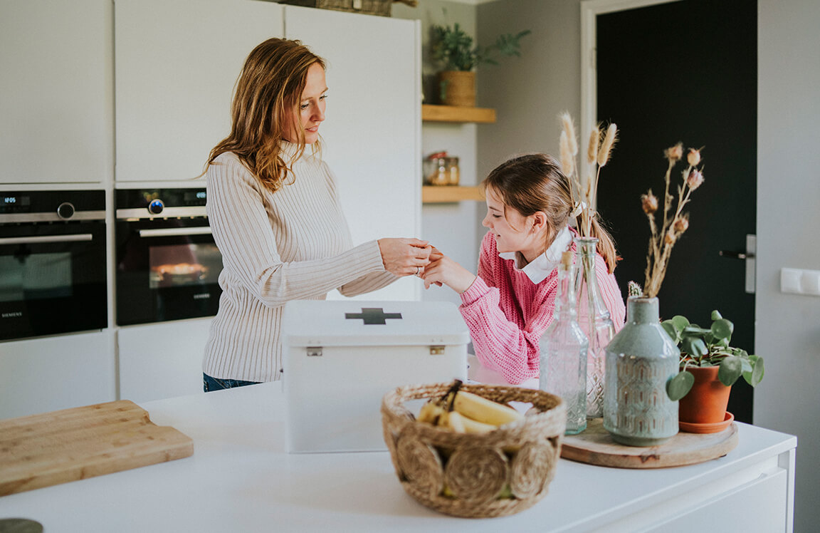 Moeder plakt pleister bij dochter