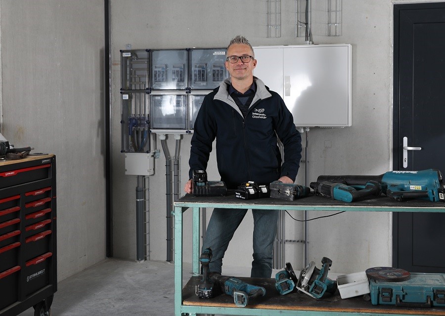 Emile van Nieuwenhoven staat aan een werktafel met daarop divers accu-gereedschap. - Foto: Natasja Beverloo
