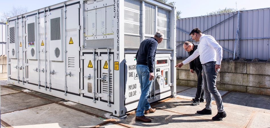 3 mannen inspecteren een container voor energieopslag.