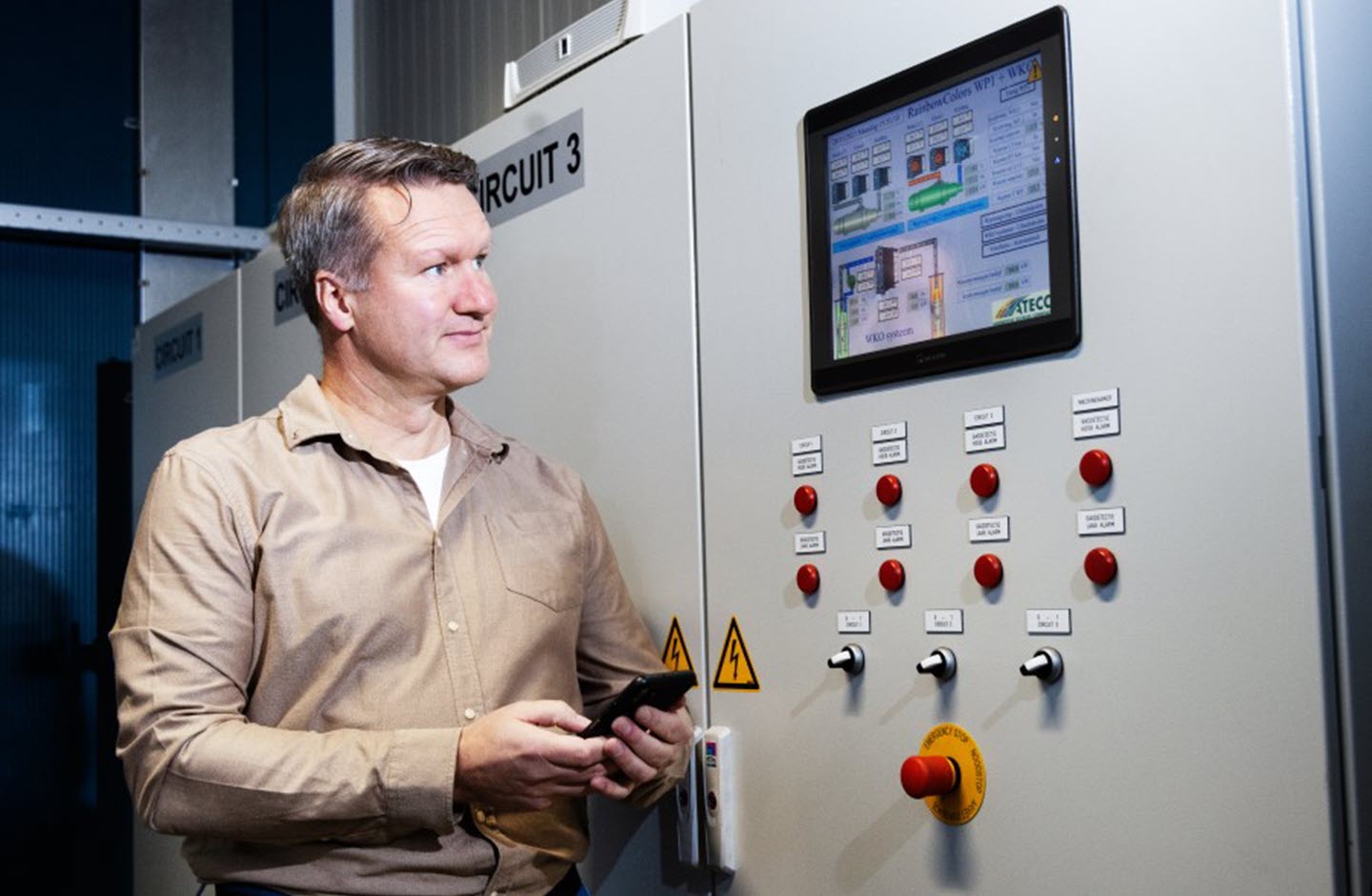 Tulpenbroeier Bas Karsten staat naast de regelkast van een elektrische installatie.