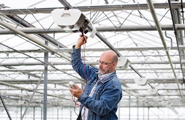 Man keurt belichting in een kas