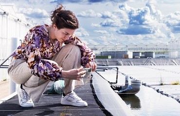 Vrouw zit gehurkt bij een waterbassin