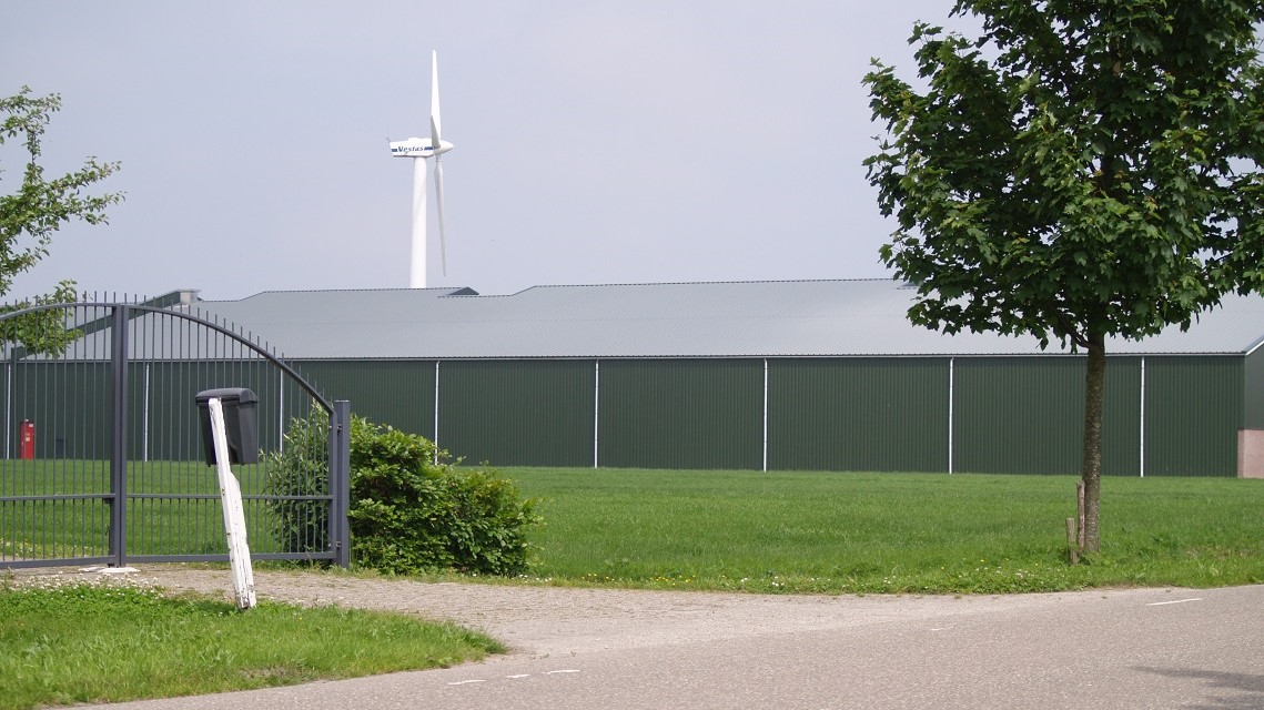 Een bewaarloods, met op de achtergrond een windmolen.