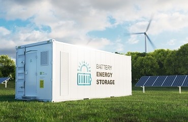 Een energie-opslagsysteem, met op de achtergrond zonnepanelen en een windmolen.