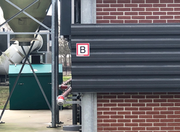 Een fire defender is een rode buis langs de stal, die een blusgordijn van water kan maken.