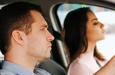 Man en vrouw zitten achter het stuur in de auto | Interpolis verzekeringen