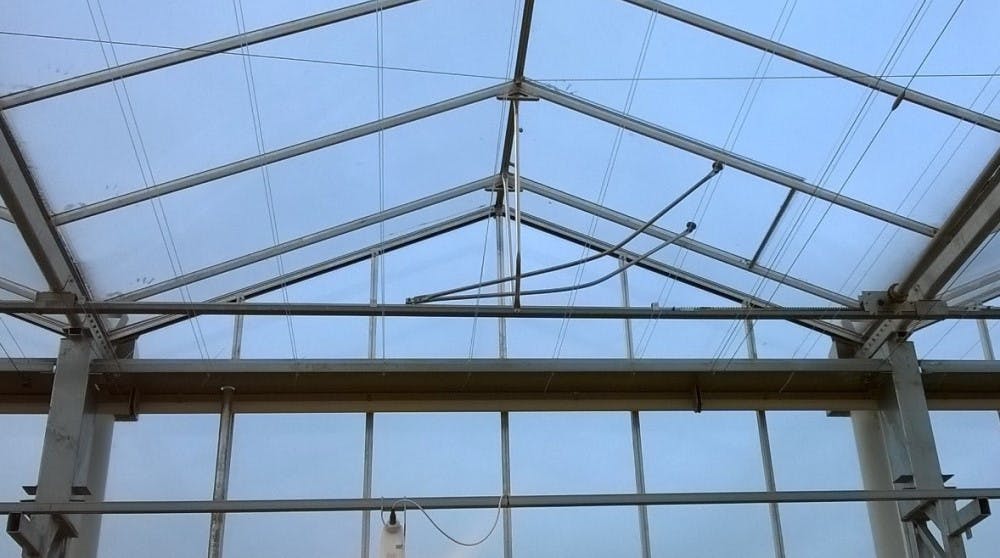 Kromgetrokken opdrukkers van de luchtramen in het dak van een glazen kas.
