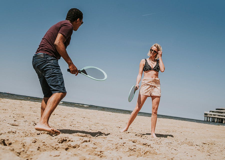 Man en vrouw spelen beachball op het strand | Interpolis doorlopende reisverzekering