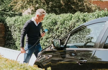 Man die zijn elektrische auto aan de oplader gaat doen