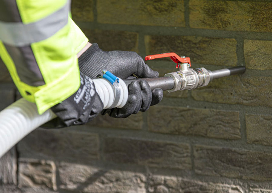 Persoon vult de muur met isolatie