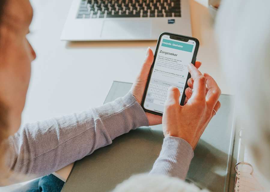 Een vrouw bekijkt de Zorgzoeker op haar telefoon.