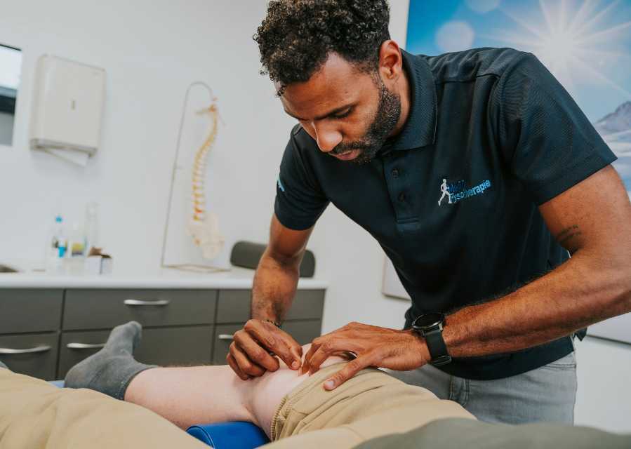 Een fysiotherapeut behandelt de knie van een patiënt. 