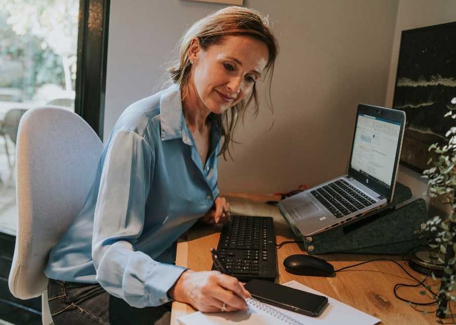 Een vrouw werkt op haar laptop aan een bureau.