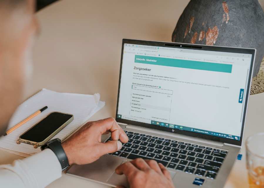 Persoon gebruikt de zorgzoeker op een laptop.