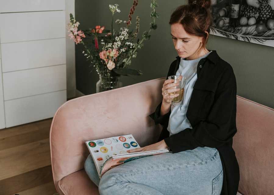 Vrouw leest een tijdschrift op de bank