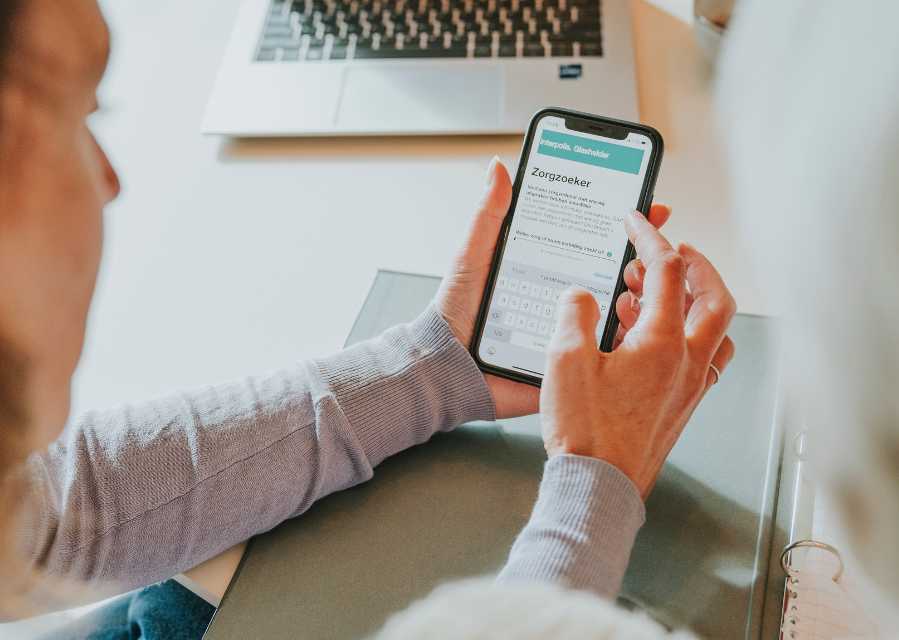 Een persoon bekijk de Interpolis Zorgzoeker op de telefoon. 