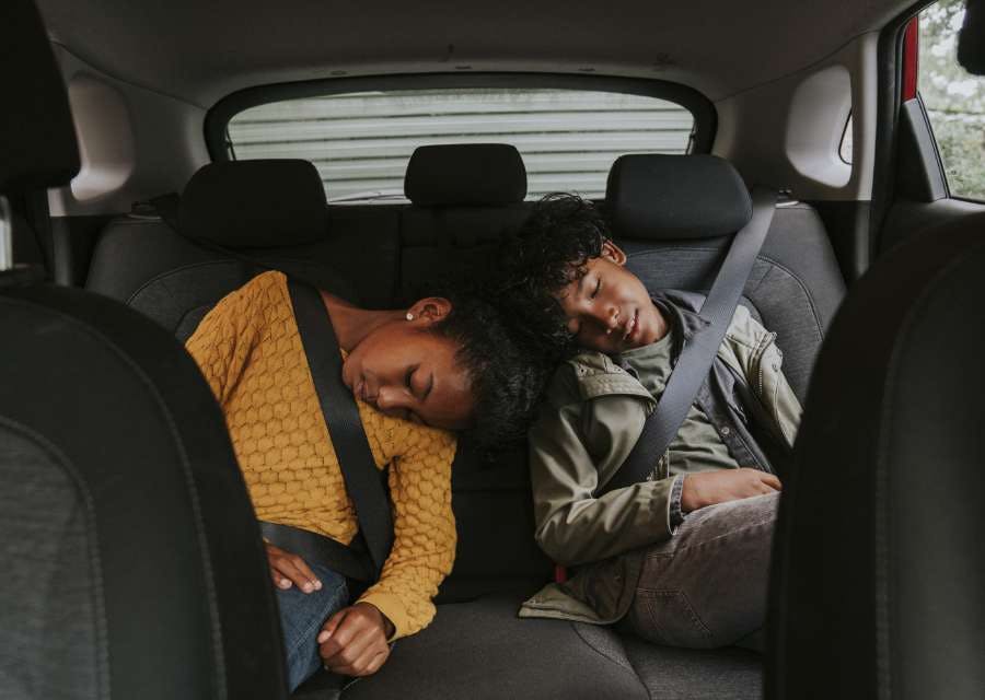 2 kinderen slapen op de achterbank van de auto | Interpolis verzekeringen