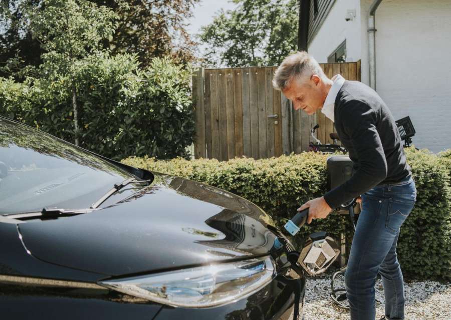 Man stopt de laadkabel in zijn elektrische auto | Interpolis verzekeringen