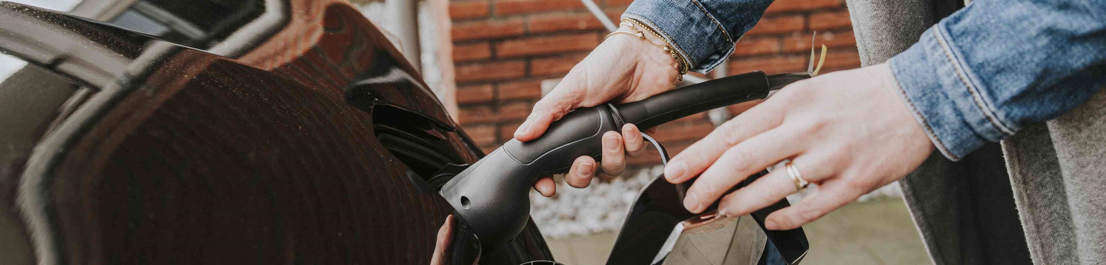 Vrouw stopt de laadkabel van een elektrische auto erin | Interpolis verzekeringen