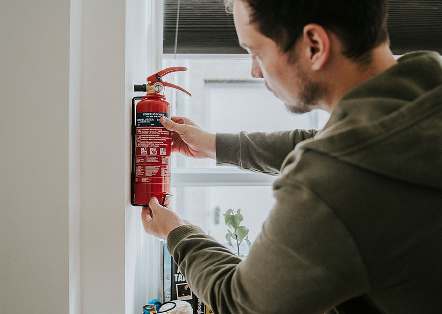 Man hangt een brandblusser op.