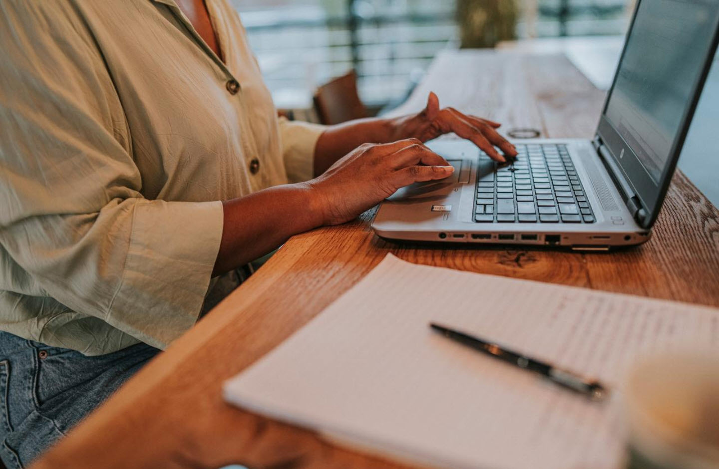 Een opengeklapte laptop; iemand is op het toetsenbord aan het typen.