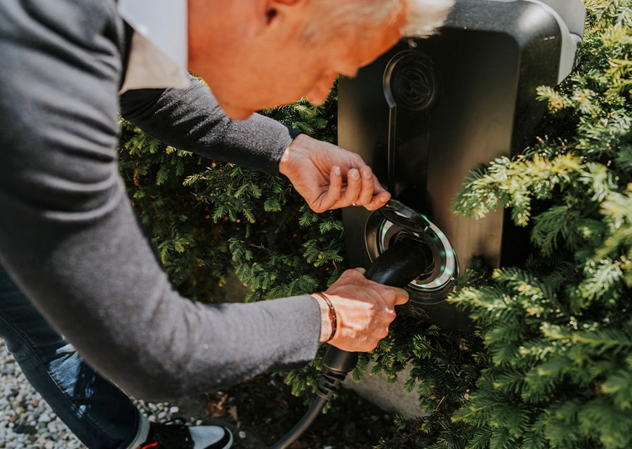 Man plugt laadkabel in | Goed geregeld met onze woonverzekeringen | Interpolis