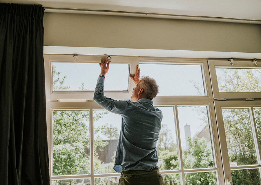 Man controleert de sloten van een raam.