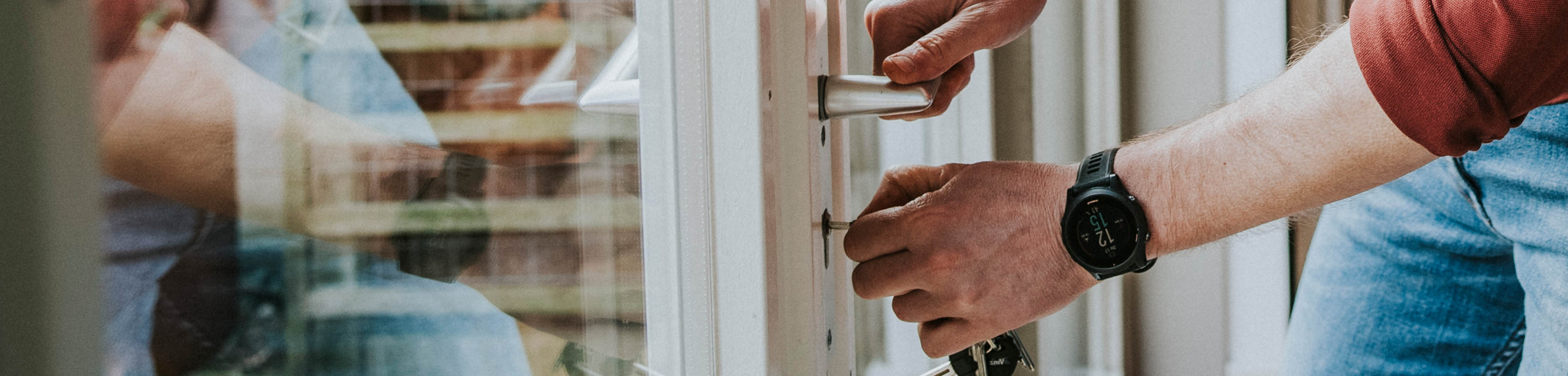 Man draait het slot van de tuindeur dicht.