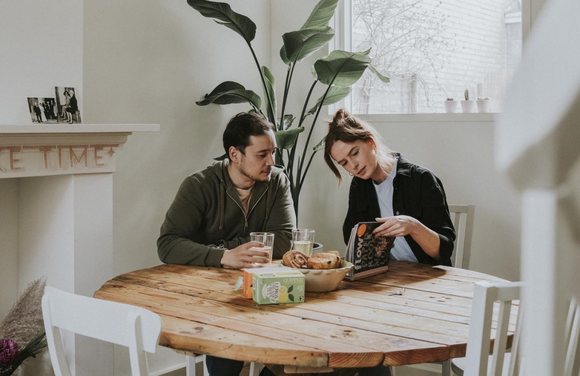 Man en vrouw die in hun woning aan tafel zitten