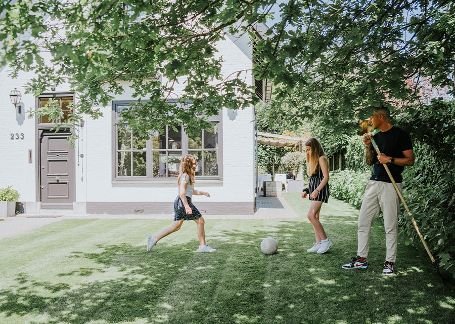 Kind speelt met ouders in de tuin | Vergroen je woning en houd je hoofd koel in de zomer | Interpolis