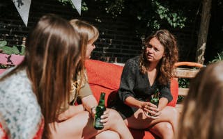 Vier vrouwen drinken buiten een drankje
