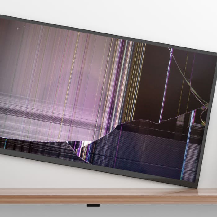 Een flatscreen tv die scheef aan de muur hangt en beschadigd is geraakt