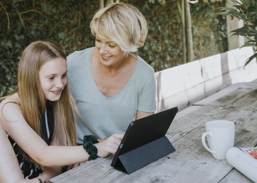 Vrouw die haar dochter helpt op een tablet