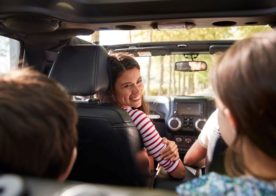 Vrouw met 2 kinderen in een auto. De auto is verzekerd met de autoverzekering van de Interpolis Alles in één Polis.