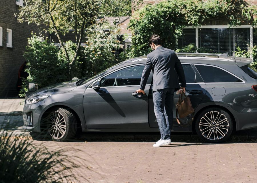 Man die het portier van zijn auto opent. Je krijgt korting op de premie van je autoverzekering als je schadevrije jaren hebt.