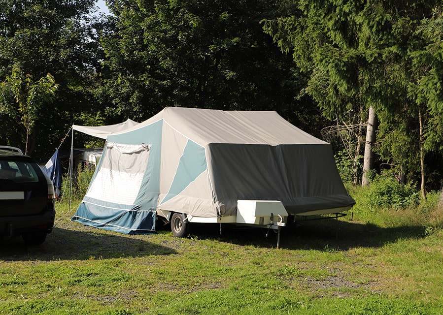 Uitgeklapte vouwwagen op de camping, die verzekerd is met een caravanverzekering
