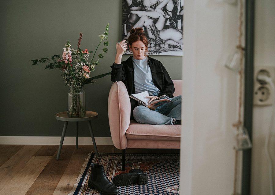 Vrouw op de bank die kiest voor een woonlastenverzekering om het risico van arbeidsongeschiktheid af te dekken